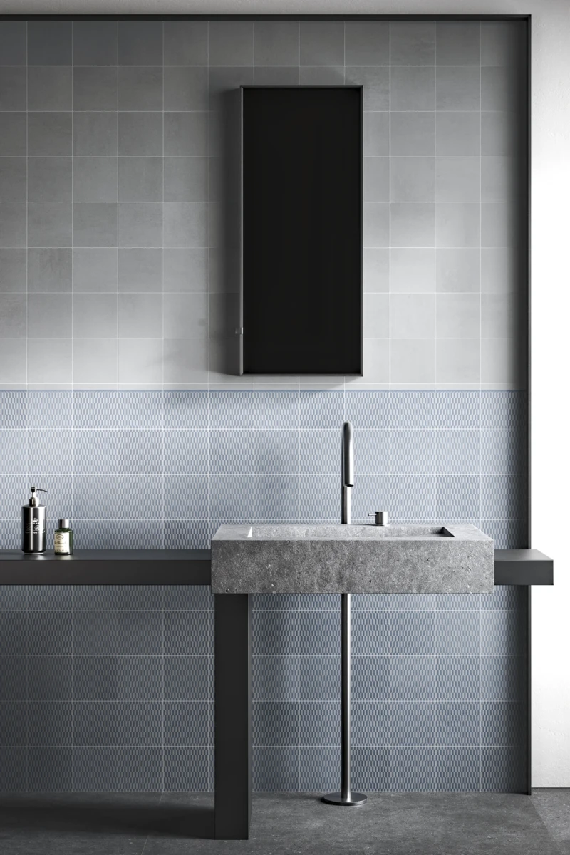 Salle de bain réalisée avec des carreaux de couleur grise et un motif de textures bleues