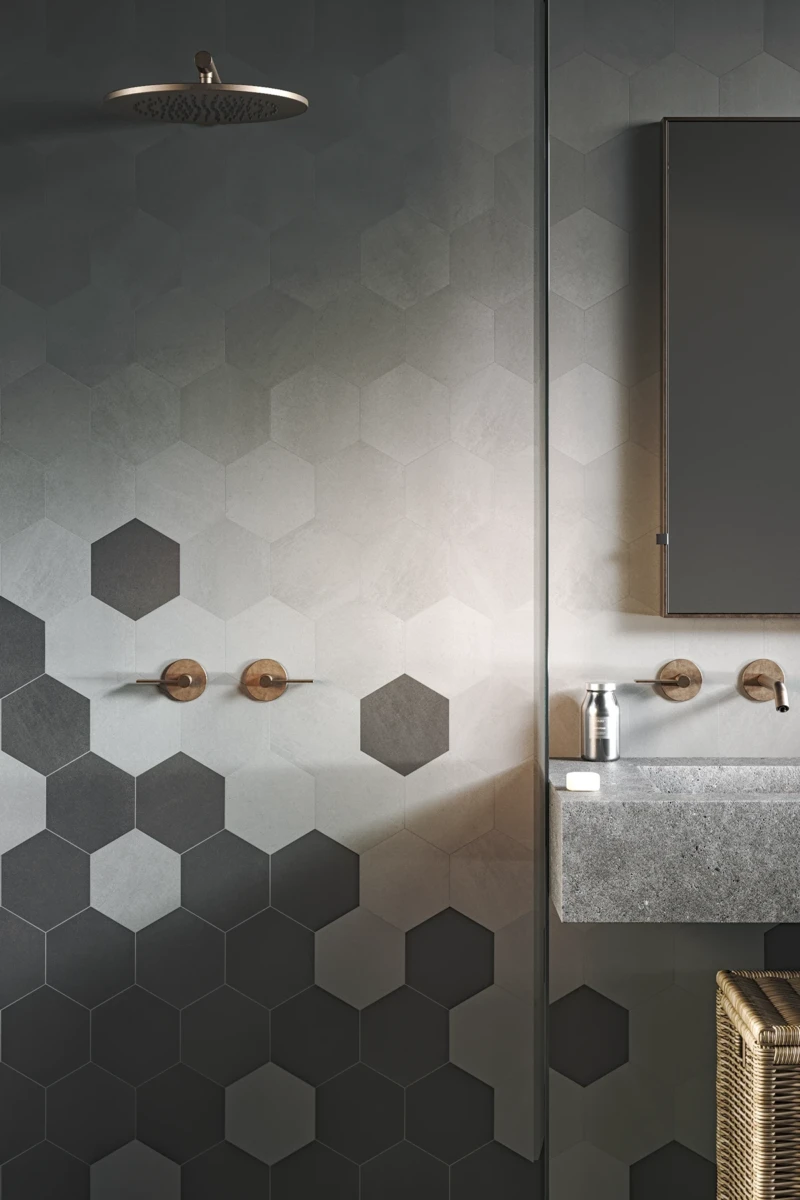 Mur de salle de bain réalisé avec une combinaison de carreaux hexagonaux gris et noirs